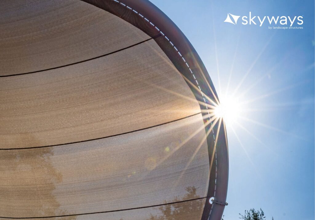 Sunlight filters through a sunshade canopy beneath a clear blue sky, with the “Skyways” logo visible in the corner.
